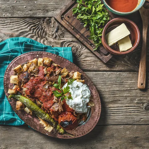 İskender Kebap mit Joghurt, Tomatensauce und gegrillter Peperoni